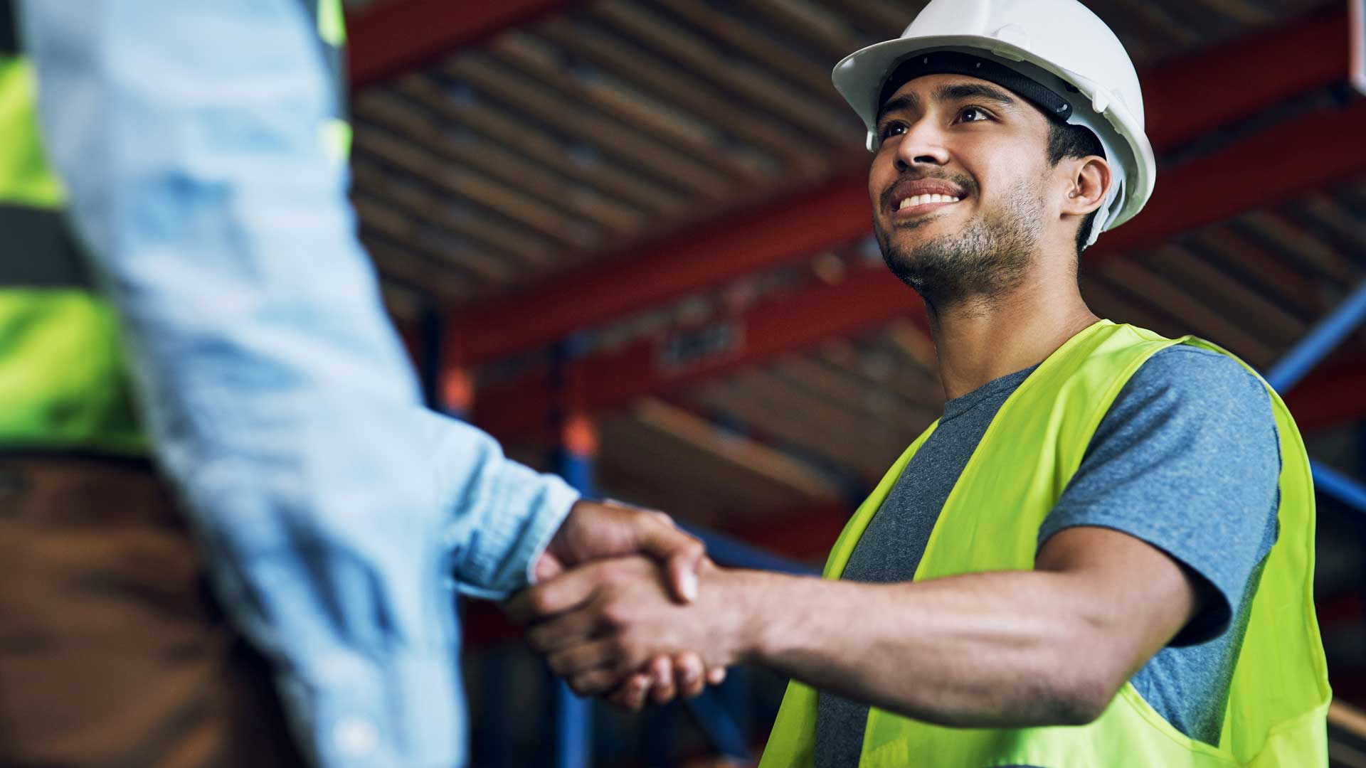 Male construction worker shaking supervisors hand.