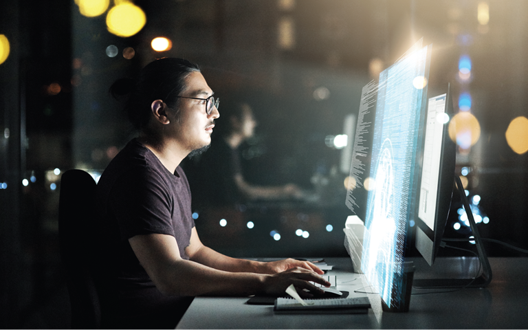 male computer programmer working late in the office