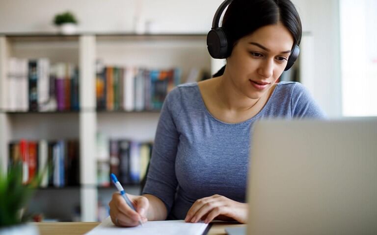 Woman with headphones looking at screen