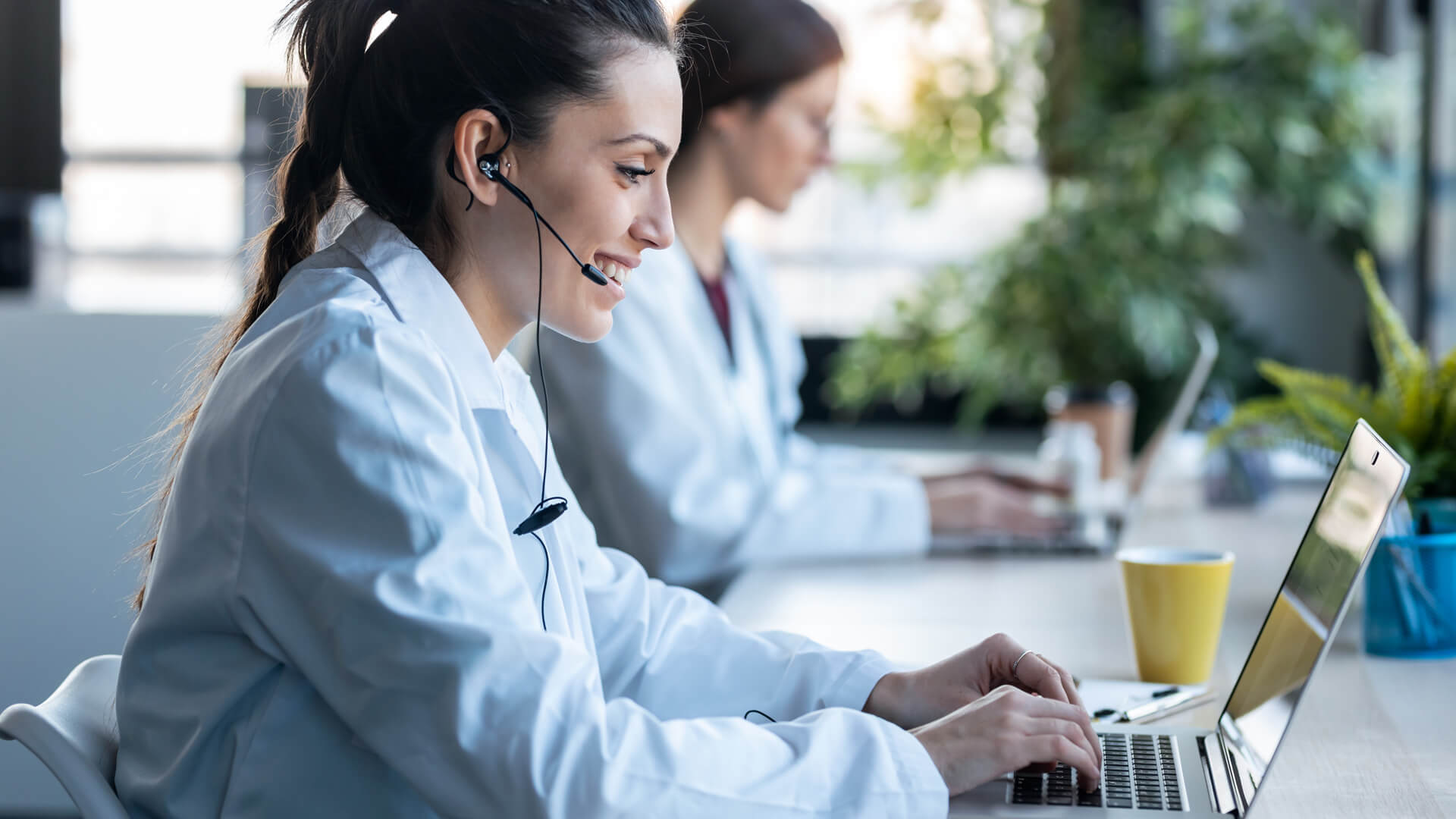 woman working on laptop with headset in global call center