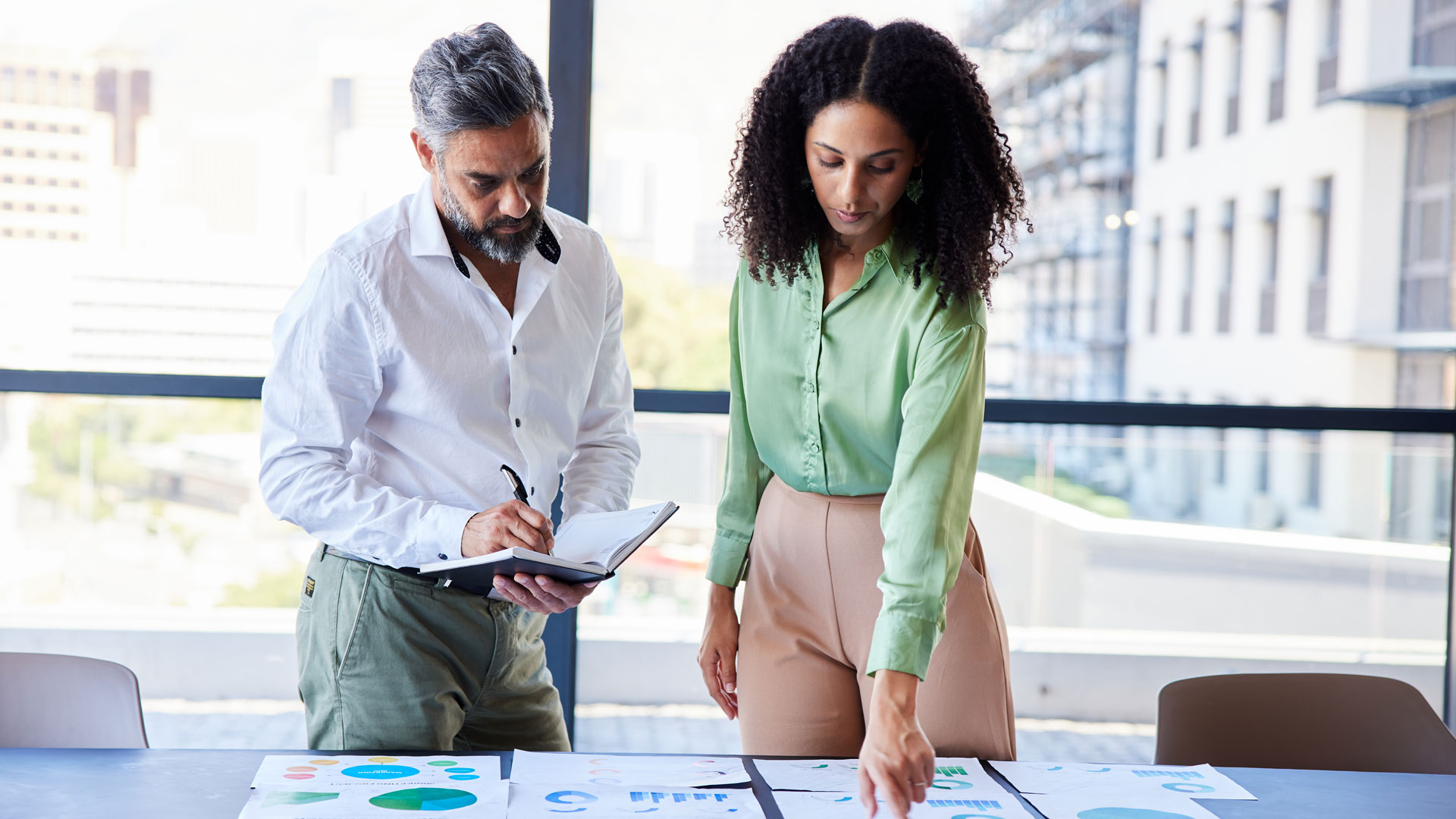 Male and female coworkers reviewing data from the 2024 Canadian labour market report.